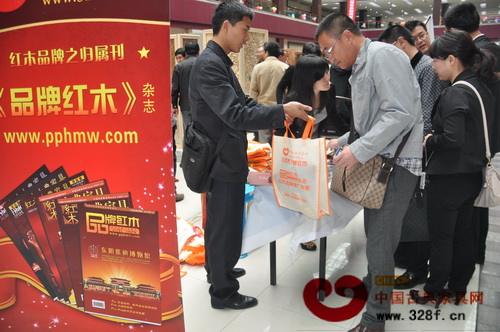 工作人員把三月份《品牌紅木》遞給經(jīng)銷商