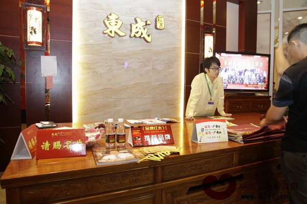 東成紅木展廳的咨詢臺上擺放著品牌推薦牌、扇子等物品