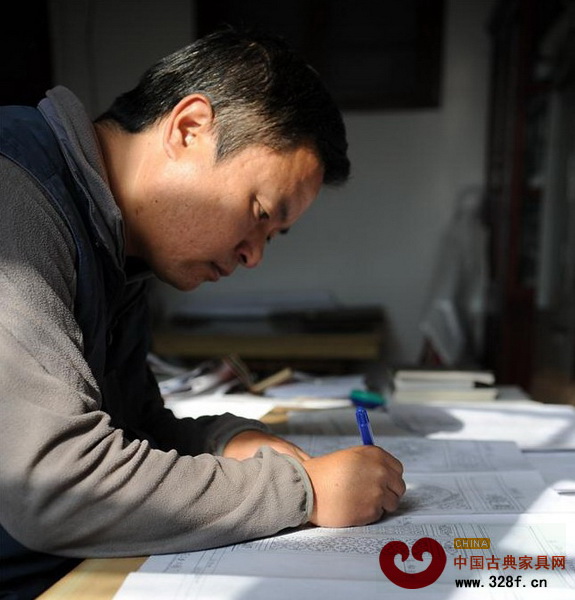 劍川木雕傳承人段四興正在規(guī)劃雕刻圖紙