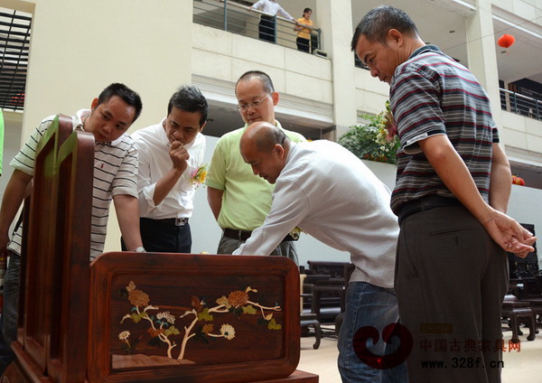 參觀者在議論紅木家具的品相