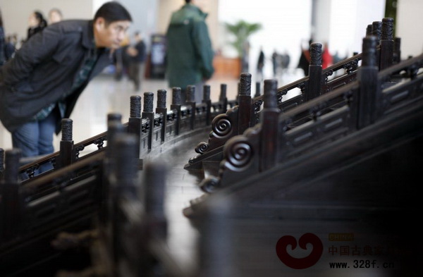 一位參觀者在“紫檀制天壇祈年殿”前駐足觀看