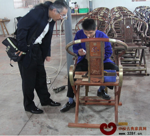 濮安國(guó)正在源天福工廠認(rèn)真觀看工匠生產(chǎn)制作交椅