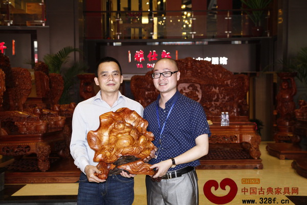 雅仕軒紅木總經(jīng)理(左)贈(zèng)予加盟商木雕工藝品