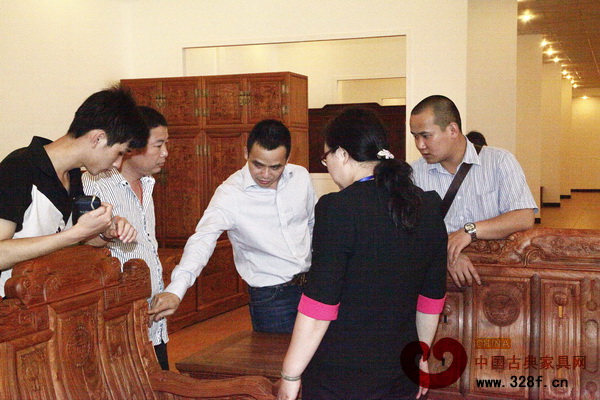 雅仕軒紅木總經(jīng)理(左三)在廠(chǎng)房展廳親自為團(tuán)友講解產(chǎn)品