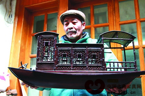 張紅根捧著紅木竹節(jié)搭建游船