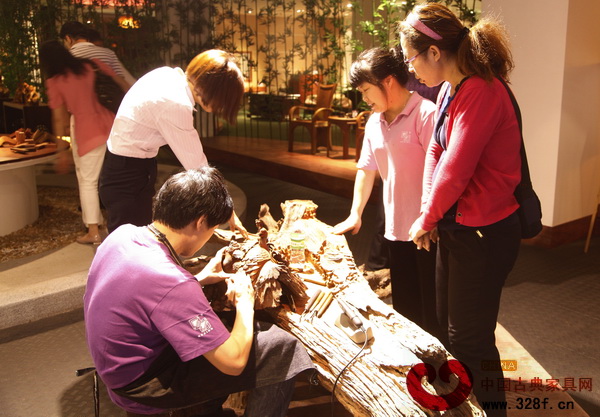 消費(fèi)者通過這種紅木投資平臺,可以親身體驗(yàn)紅木家具的工藝和文化,圖為中國銀行私人銀行廣州分部VIP客戶在欣賞合興·奇典居雕刻師傅現(xiàn)場展示的雕刻工藝