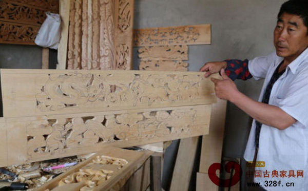木雕師傅向記者介紹著木雕作品