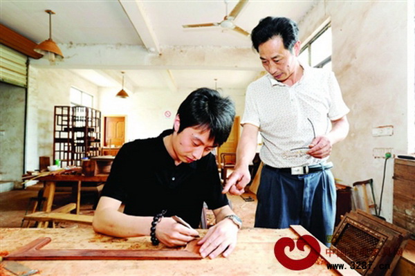 父親張建社正在指導(dǎo)兒子張文君雕刻