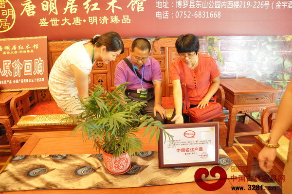 唐明居紅木的導(dǎo)購人員向業(yè)主詳細(xì)介紹紅木家具