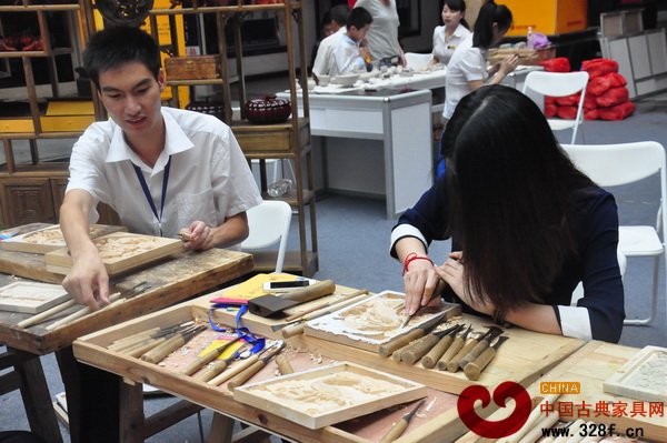 木雕DIY現(xiàn)場(chǎng),工作人員正在指導(dǎo)參與者進(jìn)行雕刻