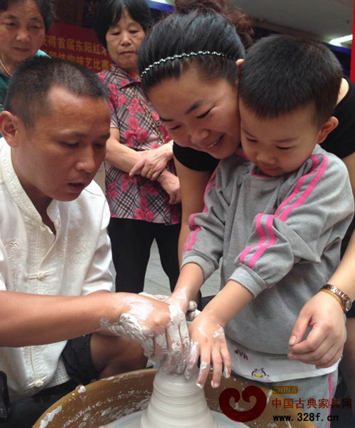 一對母子在工作人員的指導(dǎo)下進行陶藝DIY