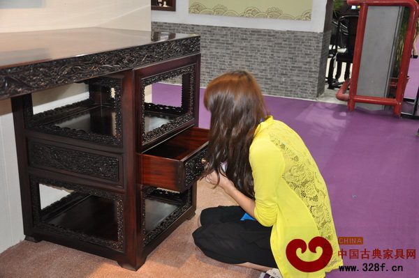 深圳文博會(huì)上,一名觀眾低身品味區(qū)氏臻品大紅酸枝家具的氣味