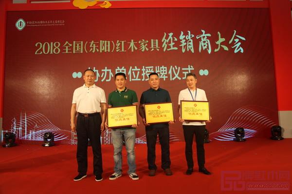 興成紅木（右二）接受2018全國（東陽）紅木家具經銷商大會協(xié)辦單位頒牌