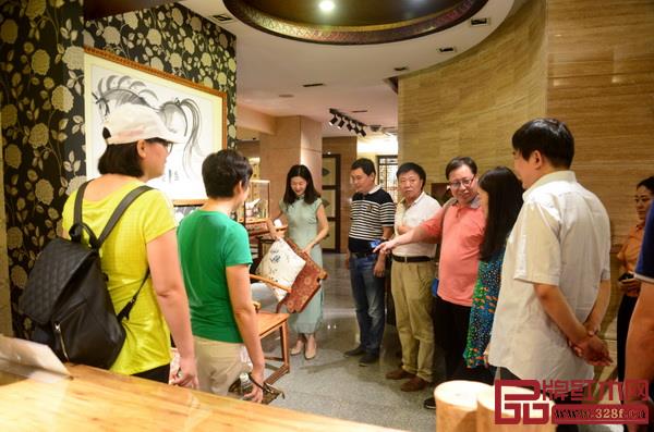  紅古軒營銷總監(jiān)楊晶（左三）為河南工程學院領導、老師一行介紹紅古軒紅木家具