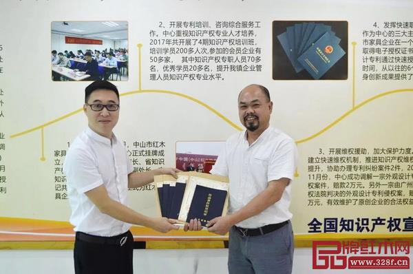 中山市紅木家具行業(yè)協(xié)會秘書長林毅昭(左)為陳正民頒發(fā)版權(quán)證書 中山市紅木家具行業(yè)協(xié)會秘書長林毅昭(左)為陳正民頒發(fā)版權(quán)證書
