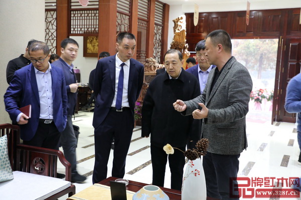 國務(wù)院參事室特邀研究員、原人力資源和社會保障部副部長、黨組副書記、東陽市紅木產(chǎn)業(yè)發(fā)展顧問楊志明（右二）、東陽市人民政府副市長蔣震雷（右三）和恒達(dá)木業(yè)董事長陳國良（右一）一同參觀恒達(dá)木業(yè)展廳，交流溝通
