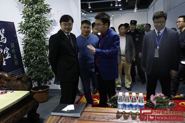 龍珍閣紅木 第十三屆東博會上龍珍閣總經(jīng)理陸勛（右二）向金華市人民政府副市長、東陽市市委書記黃敏（左一）介紹鴛鴦寶座沙發(fā)