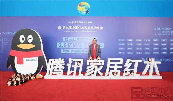 華行紅木 華行紅木總經(jīng)理黃岸峰在盛典現(xiàn)場“騰訊家居”紅木背景板前留影  