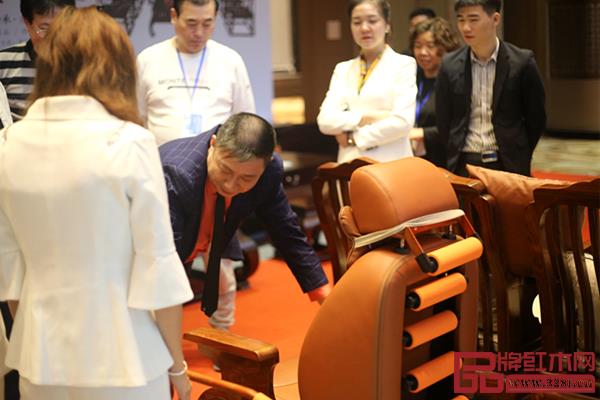榫卯大師董事長王強(qiáng)堂（左二）在經(jīng)銷商大會現(xiàn)場向經(jīng)銷商講解家具優(yōu)勢