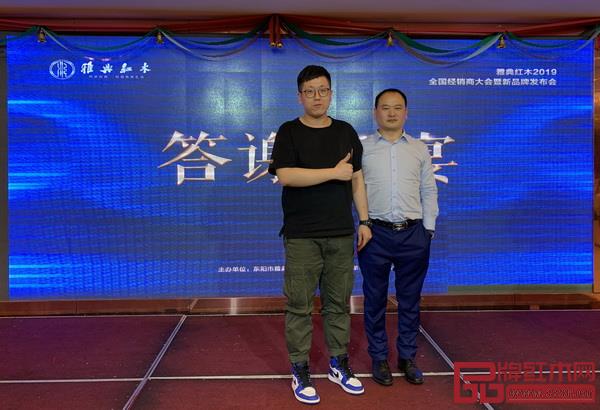  答謝晚宴的抽獎(jiǎng)環(huán)節(jié)上，獲一等獎(jiǎng)經(jīng)銷(xiāo)商（左）與雅典紅木董事長(zhǎng)包海深合影留念