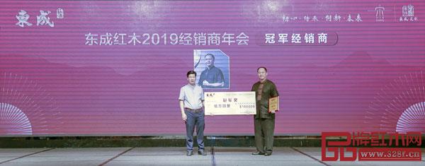 東成紅木董事長(zhǎng)張錫復(fù)（左）為東成紅木2018年度銷(xiāo)售冠軍經(jīng)銷(xiāo)商頒獎(jiǎng)