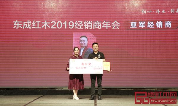 東成紅木副董事長(zhǎng)林霞（左）為東成紅木2018年度銷(xiāo)售亞軍經(jīng)銷(xiāo)商頒獎(jiǎng)