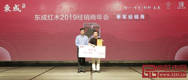 東成紅木營(yíng)銷(xiāo)總經(jīng)理曾東陽(yáng)（左）為東成紅木2018年度銷(xiāo)售季軍經(jīng)銷(xiāo)商頒獎(jiǎng)