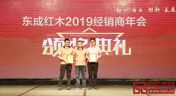 東成紅木品牌總監(jiān)阮家鵬（中）為“東成紅木2018年度最佳服務(wù)經(jīng)銷(xiāo)商”頒獎(jiǎng)