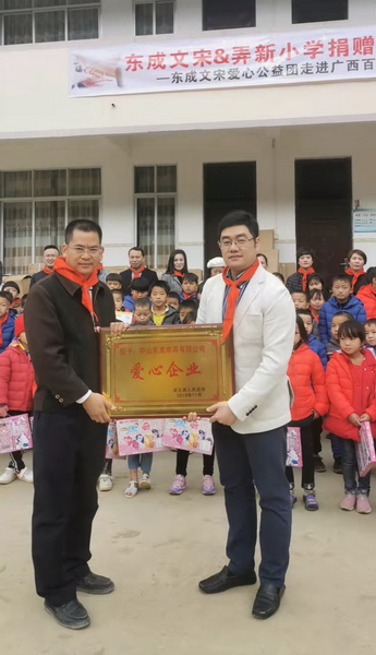 廣西自治區(qū)黨委組織部掛任凌云縣委常委、副縣長邱海富（左）為東成紅木頒發(fā)牌匾，東成紅木營銷總經(jīng)理曾東陽（右）代表企業(yè)接受授牌