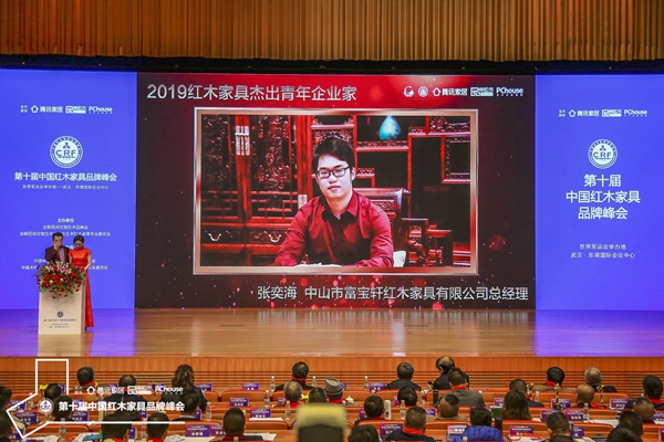 紅木品牌峰會(huì)現(xiàn)場(chǎng)在播放張奕海榮獲“2019紅木家具杰出青年企業(yè)家”的頒獎(jiǎng)視頻 紅木品牌峰會(huì)現(xiàn)場(chǎng)在播放張奕海榮獲“2019紅木家具杰出青年企業(yè)家”的頒獎(jiǎng)視頻