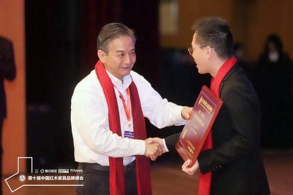 海南花梨文化研究會會長張志揚(左)為大家之家頒發(fā)“2019黃花梨家具熱門品牌”牌匾 海南花梨文化研究會會長張志揚(左)為大家之家頒發(fā)“2019黃花梨家具熱門品牌”牌匾