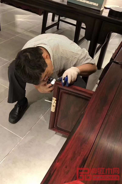 著名木材檢驗(yàn)鑒定專家陳少仁用特定的檢測設(shè)備檢驗(yàn)家具的各個(gè)邊角，不放過任何一處死角