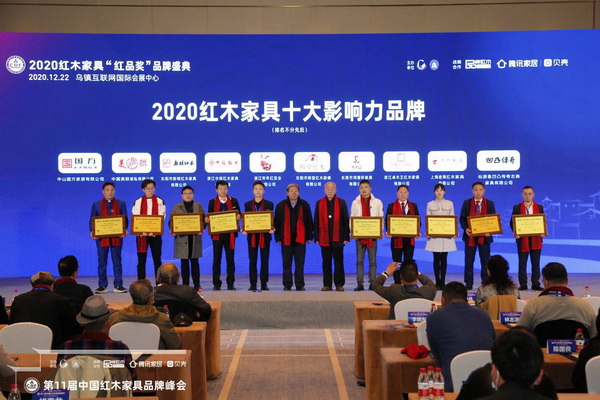 新明紅木總經(jīng)理張群樂（左三）領(lǐng)取“2020紅木家具十大影響力品牌”并和國家文物局原副局長張柏（左六）、中國紅木家具技術(shù)專家曹新民（右六）合影