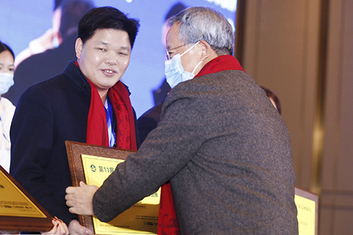 華南農(nóng)業(yè)大學(xué)博士生導(dǎo)師李凱夫（右一）為偉明軒紅木頒獎(jiǎng)，董事長(zhǎng)張石乃（左一）上臺(tái)領(lǐng)獎(jiǎng)