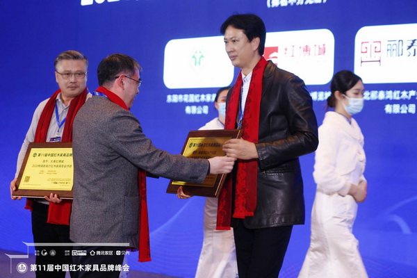 酈泰鴻紅木產(chǎn)業(yè)園執(zhí)行董事劉冠沖（右二）上臺接過“2020紅木家具特具影響力專業(yè)市場”牌匾