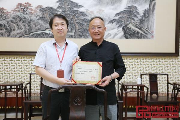 廣東省博物館現任館長肖海明向魯班木藝創(chuàng)始人、中國傳統(tǒng)工藝大師李愛金頒發(fā)力作捐贈證書