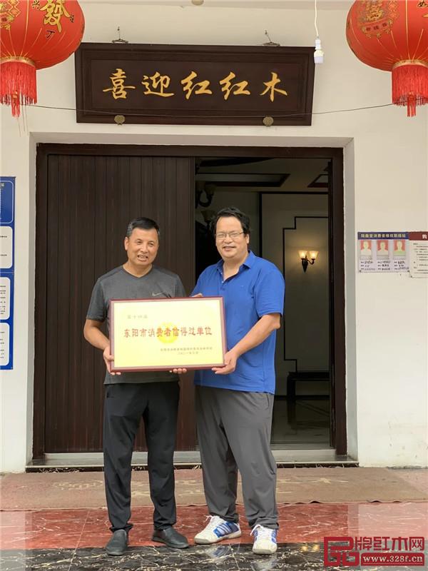 東陽(yáng)市消費(fèi)者協(xié)會(huì)秘書(shū)長(zhǎng)韋響亮與喜迎紅紅木董事長(zhǎng)陸飛躍(左一)合影留念 東陽(yáng)市消費(fèi)者協(xié)會(huì)秘書(shū)長(zhǎng)韋響亮與喜迎紅紅木董事長(zhǎng)陸飛躍(左一)合影留念