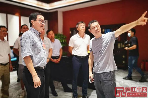 中國家具協(xié)會副理事長、紅古軒品牌創(chuàng)始人吳赤宇（右一）為中山市人大常委會副主任關(guān)瑞麟（左三）、中山市人大常委會委員、教科文衛(wèi)外僑工委主任鄺偉東（右二）介紹紅古軒企業(yè)概況