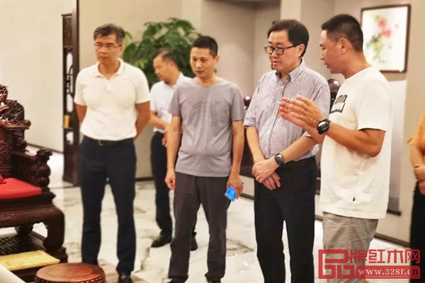 中國傳統(tǒng)工藝大師、紅古軒生產(chǎn)廠長李仲良（右一）為市人大領(lǐng)導(dǎo)一行人講解紅古軒產(chǎn)品