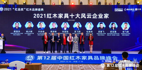 第十一屆全國(guó)政協(xié)委員、國(guó)家文物局原副局長(zhǎng)張柏（左四）、中國(guó)收藏家協(xié)會(huì)副會(huì)長(zhǎng)維佳（右三），為“2021紅木家具十大風(fēng)云企業(yè)家”頒獎(jiǎng)（部分獲獎(jiǎng)?wù)咭驗(yàn)橐咔槲茨艿綀?chǎng)）