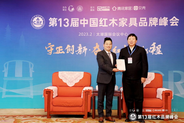  中共第十八屆中央委員、全國政協文化文史與學習委員會副主任葉小文（右）向優(yōu)秀紅木家具企業(yè)代表中信紅木董事長李忠信（左）贈送個人著作