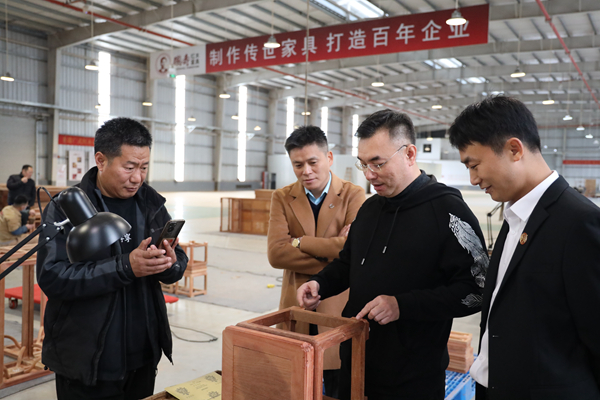 陳淦凡董事長為到訪經(jīng)銷商介紹國壽紅木精品細節(jié)