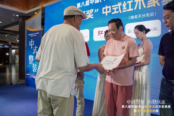 全聯(lián)藝術(shù)紅木家具專業(yè)委員會專家顧問、清華大學(xué)家具設(shè)計高研班特邀教授彭亮（左）為紅寶軒董事長、央璽品牌創(chuàng)始人曹兆庭（中）頒獎